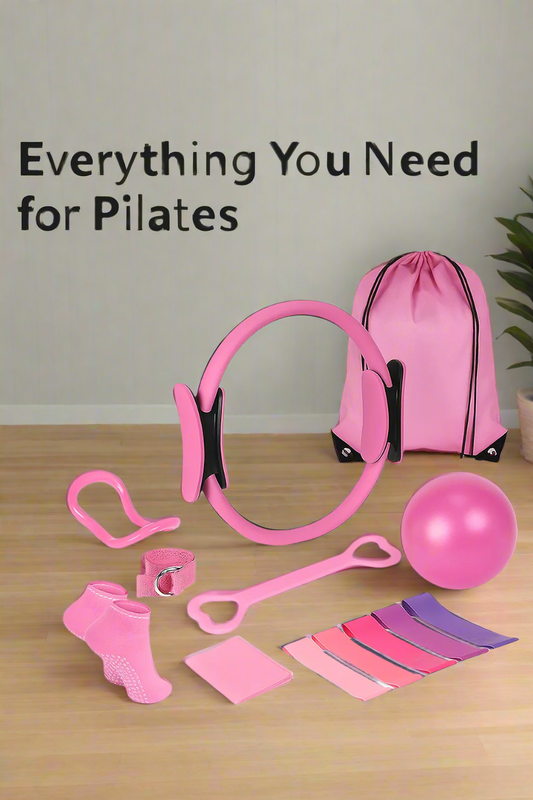Collection of pink Pilates equipment including bands, ball, and straps on a white background.